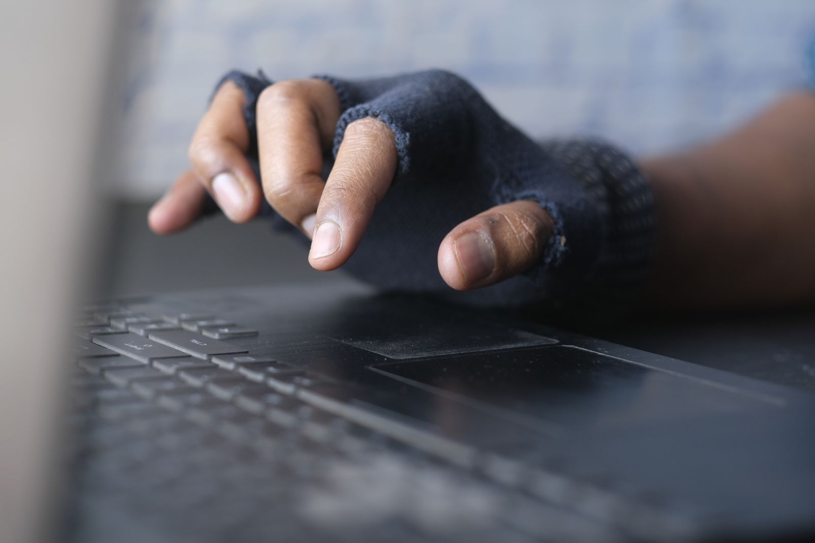 Een hand aan een laptop met een waarschuwing voor een verdachte e-mail; phishing en cybersecurity voor KMO's